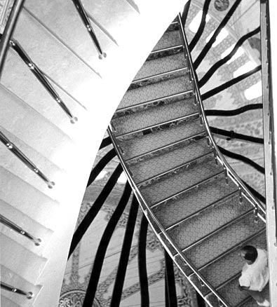 B&W man climes curving staircases