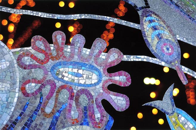 Multi-colored mosaic of sea creatures, night lights rise like bubbles