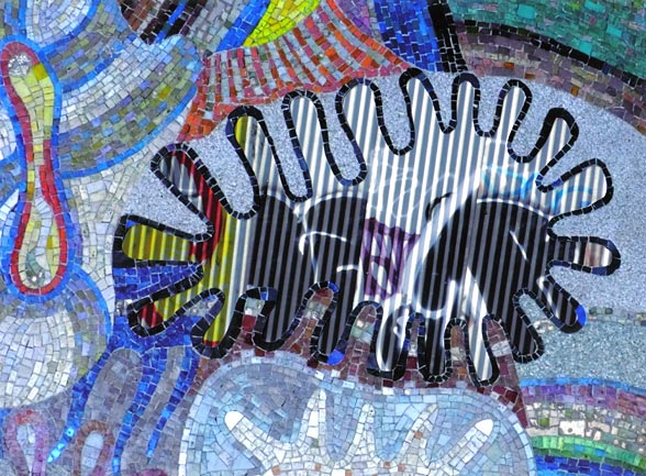 Graffiti in corrugated fence set in multi-colored mosaic of sea creatures