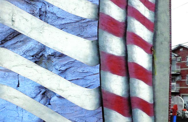 Folds of the red and white stripes of the American flag painted on the side of a residential building.