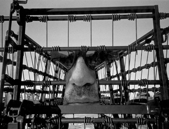 B&W face surrounded by threatening farm equipment