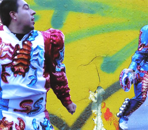 Man in white and red satin costume with red sequin scorpion, dancing in the street.