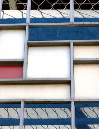 Geometric composition in white, grey, blue with a small square of red