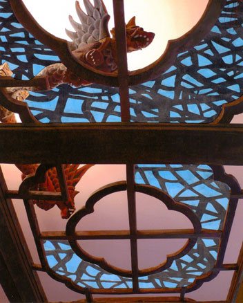 Looking up at Indonesian dragons on top of an old wooden Chinese bed